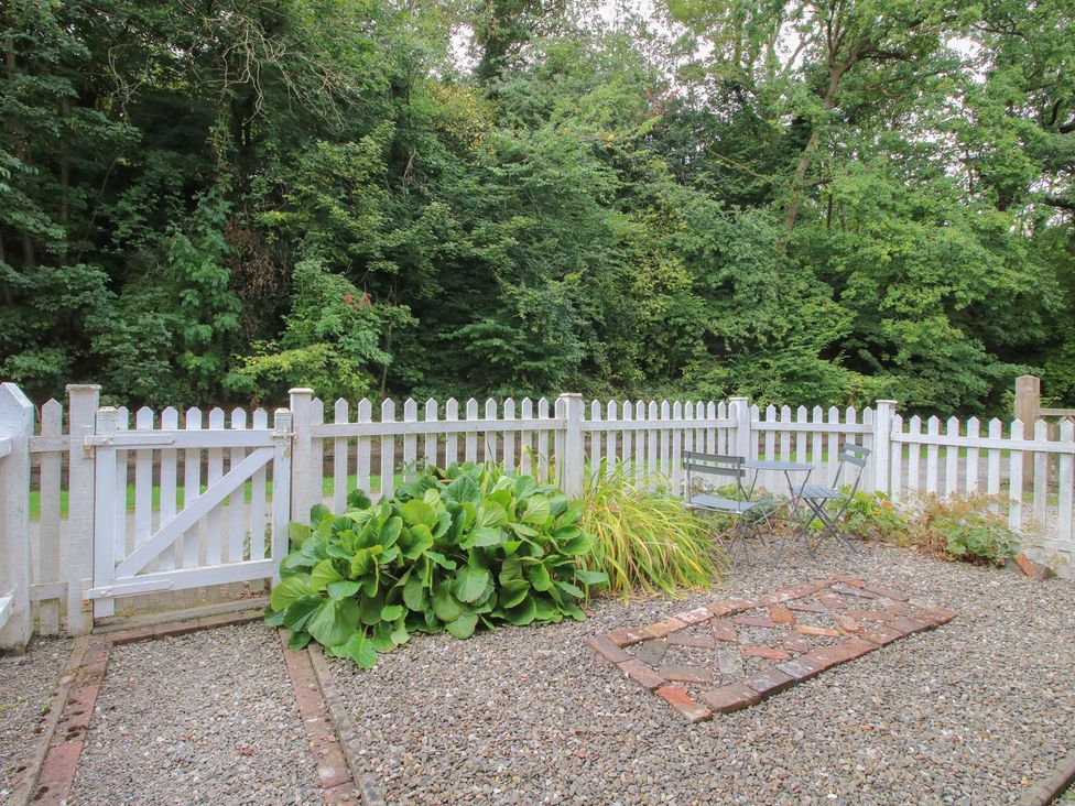 A garden with a fence, gate, table and chairs at 2 Aqueduct Cottages Chirk Bank near Chirk