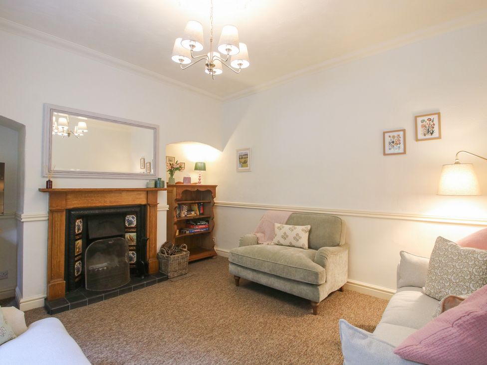 A living room with a fireplace and bookshelf at 2 Aqueduct Cottages Chirk Bank near Chirk