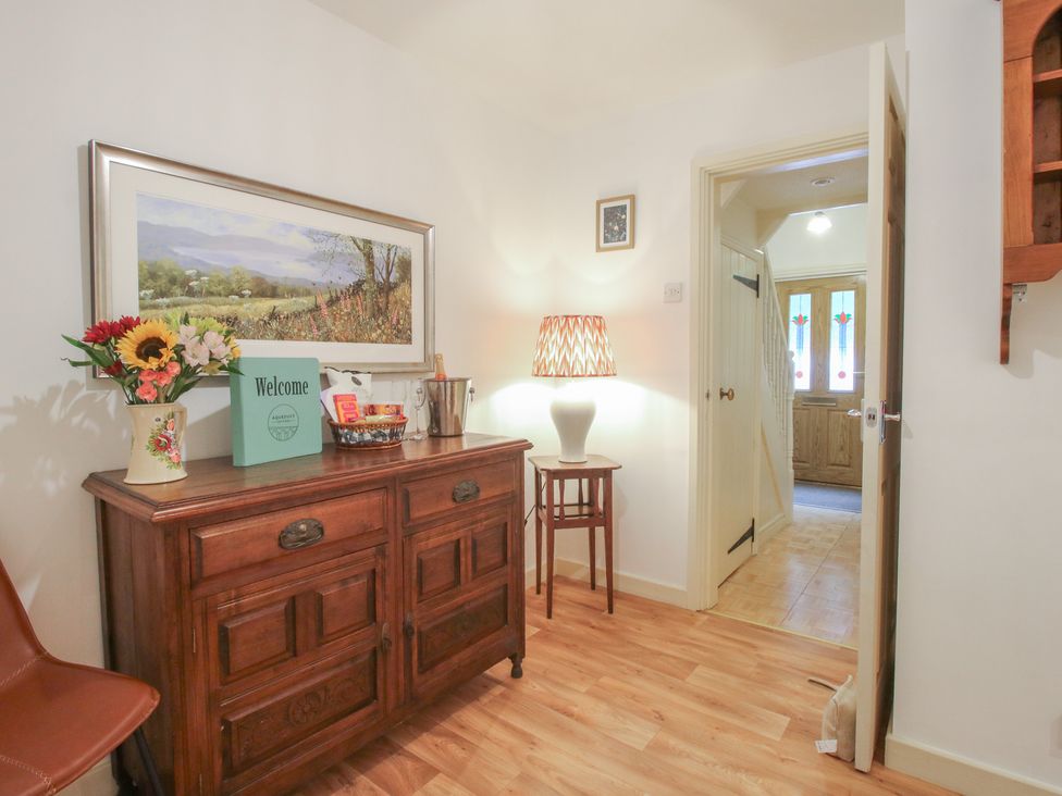 A hallway with a wooden table and flowers at 2 Aqueduct Cottages Chirk Bank near Chirk