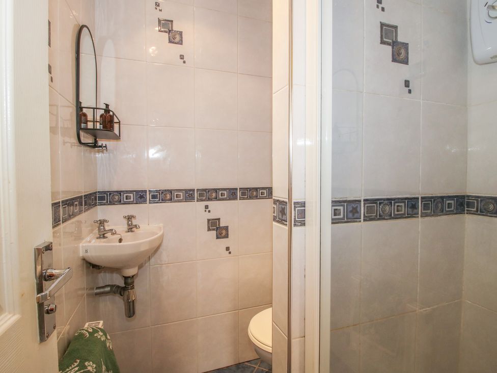 A bathroom with a sink, toilet, and shower at 2 Aqueduct Cottages Chirk Bank near Chirk