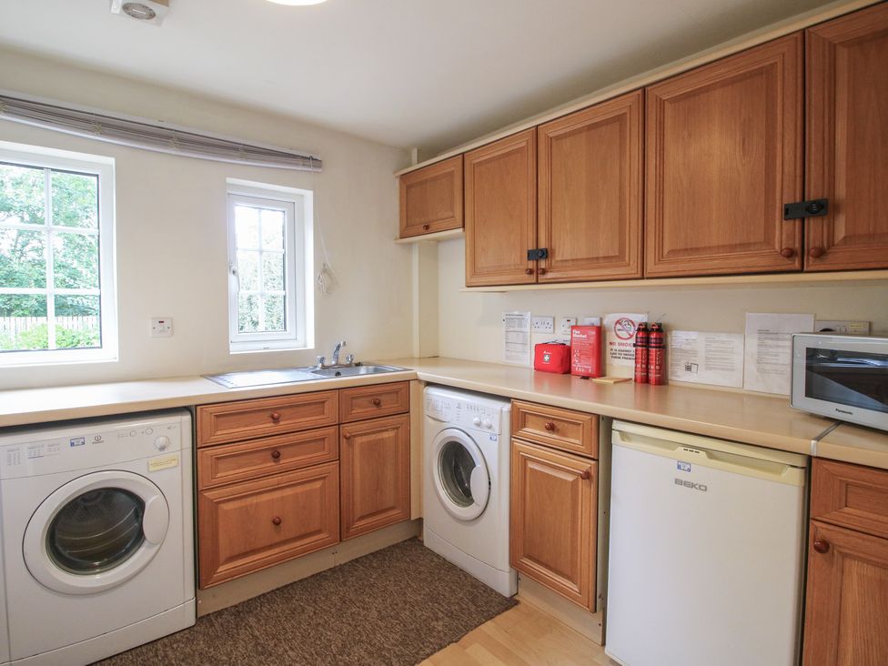 A laundry room with appliances and a sink at 2 Aqueduct Cottages Chirk Bank near Chirk