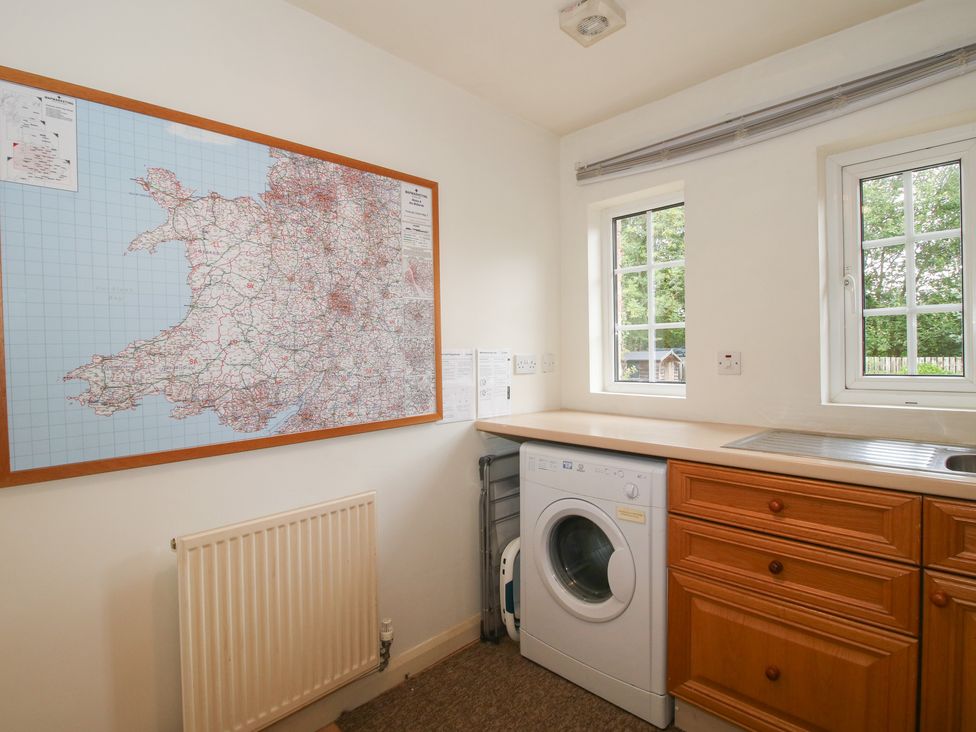 A utility room with a washing machine and map on the wall at 2 Aqueduct Cottages Chirk Bank near Chirk