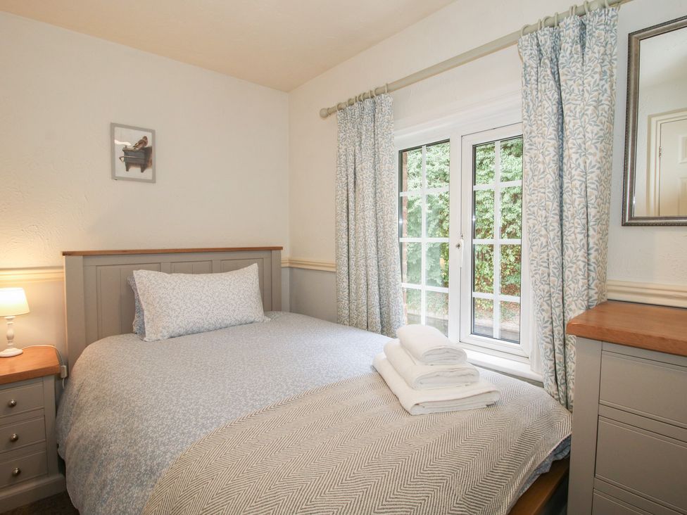 A bedroom with a bed and dresser at 2 Aqueduct Cottages Chirk Bank near Chirk