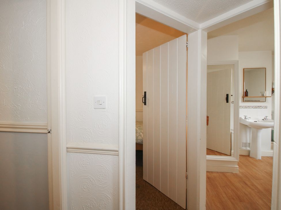 A bedroom with a door leading to a bathroom at 2 Aqueduct Cottages in Chirk Bank near Chirk