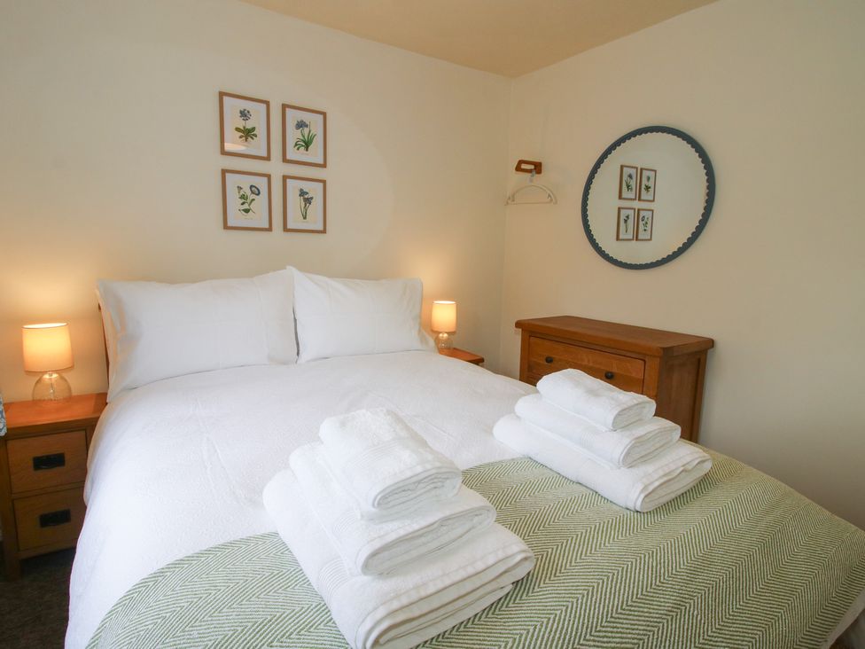 A bedroom with a bed and towels arranged on the bed at 2 Aqueduct Cottages Chirk Bank near Chirk