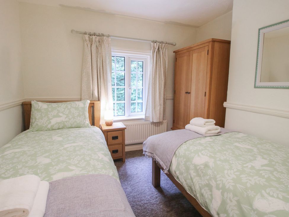 A bedroom with two single beds and a wardrobe at 2 Aqueduct Cottages Chirk Bank near Chirk