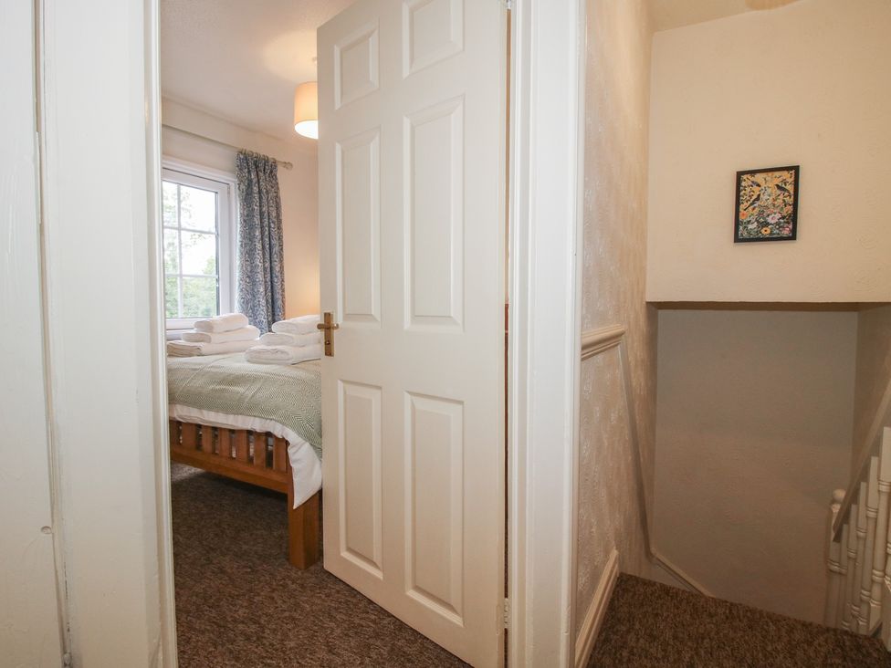 A doorway leading to a bedroom with a bed and towels at 2 Aqueduct Cottages Chirk Bank near Chirk