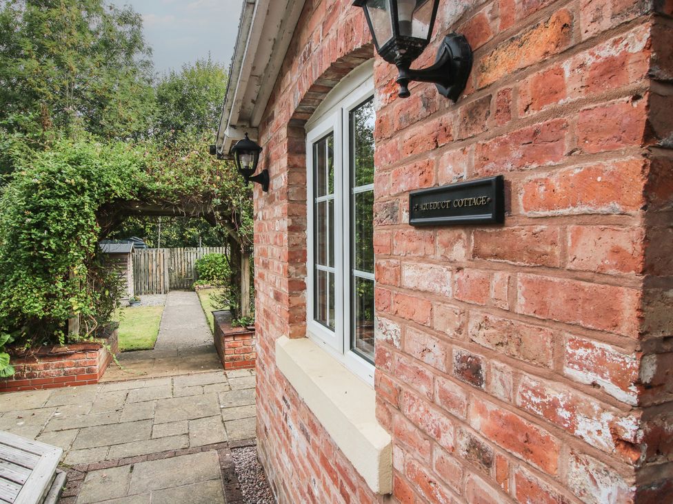 A brick exterior with a window and lanterns at 2 Aqueduct Cottages in Chirk Bank near Chirk