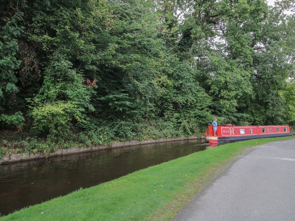 A narrowboat on a canal by trees at 2 Aqueduct Cottages Chirk Bank near Chirk