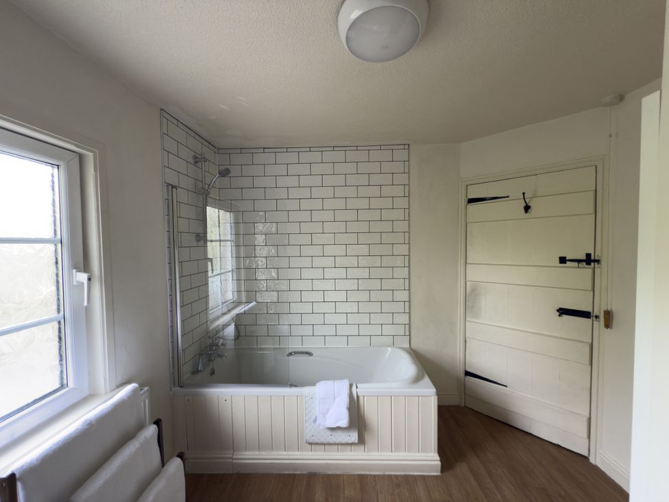 A bathroom with a bathtub and shower at 2 Aqueduct Cottages Chirk Bank near Chirk
