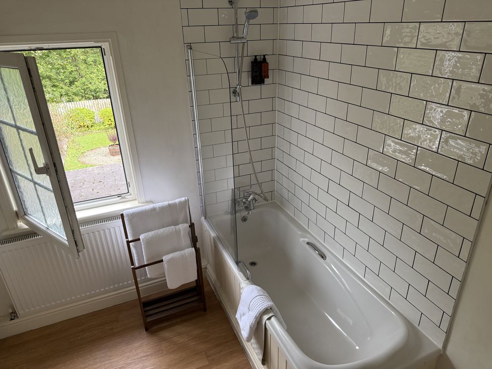 A bathroom with a bathtub and towels at 2 Aqueduct Cottages Chirk Bank near Chirk