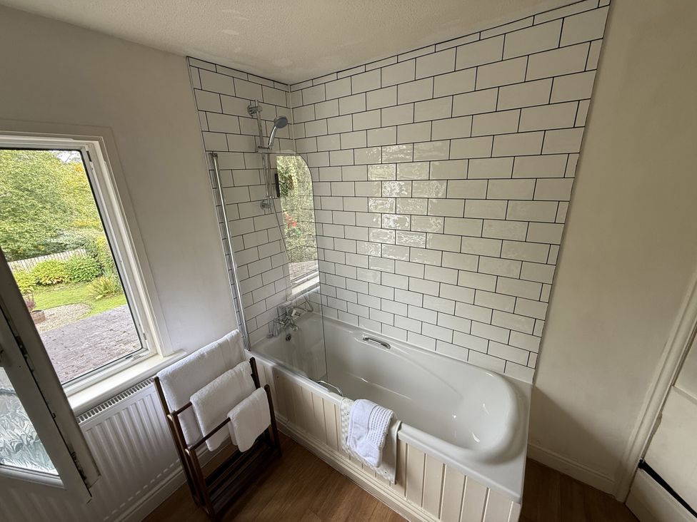 A bathroom with a bathtub and window at 2 Aqueduct Cottages Chirk Bank near Chirk