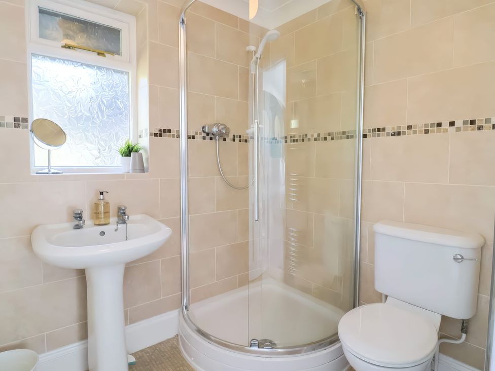 A bathroom with a shower enclosure sink and toilet at Beer View Cottage in Beer