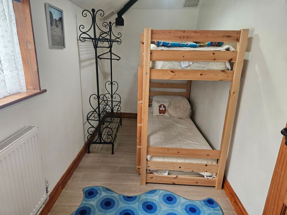 A bedroom with a bunk bed and a rack at The Coach House in Redruth