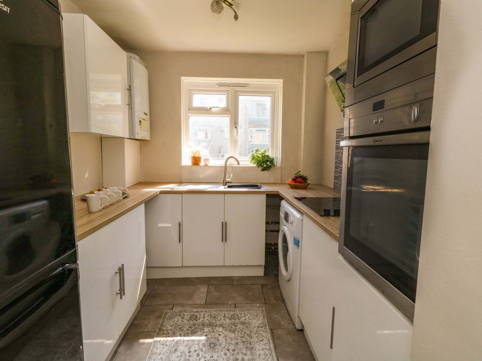 A kitchen with a sink, refrigerator, and washing machine at Lily's Pad in Weston, Portland