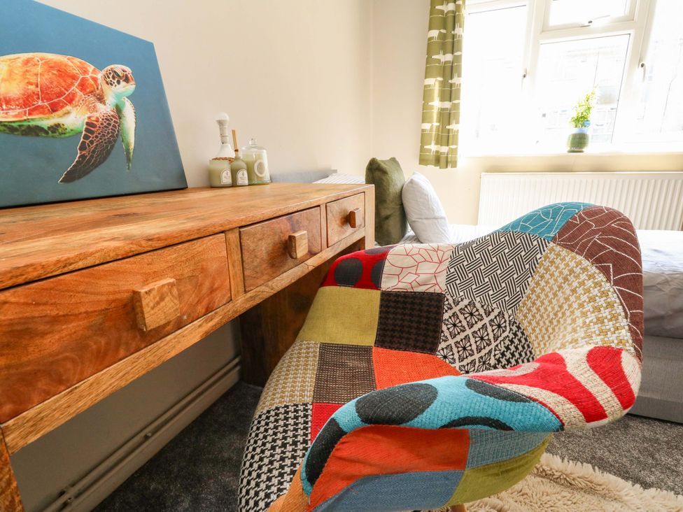 A living room with a desk and colorful chair at Lily's Pad in Weston, Portland