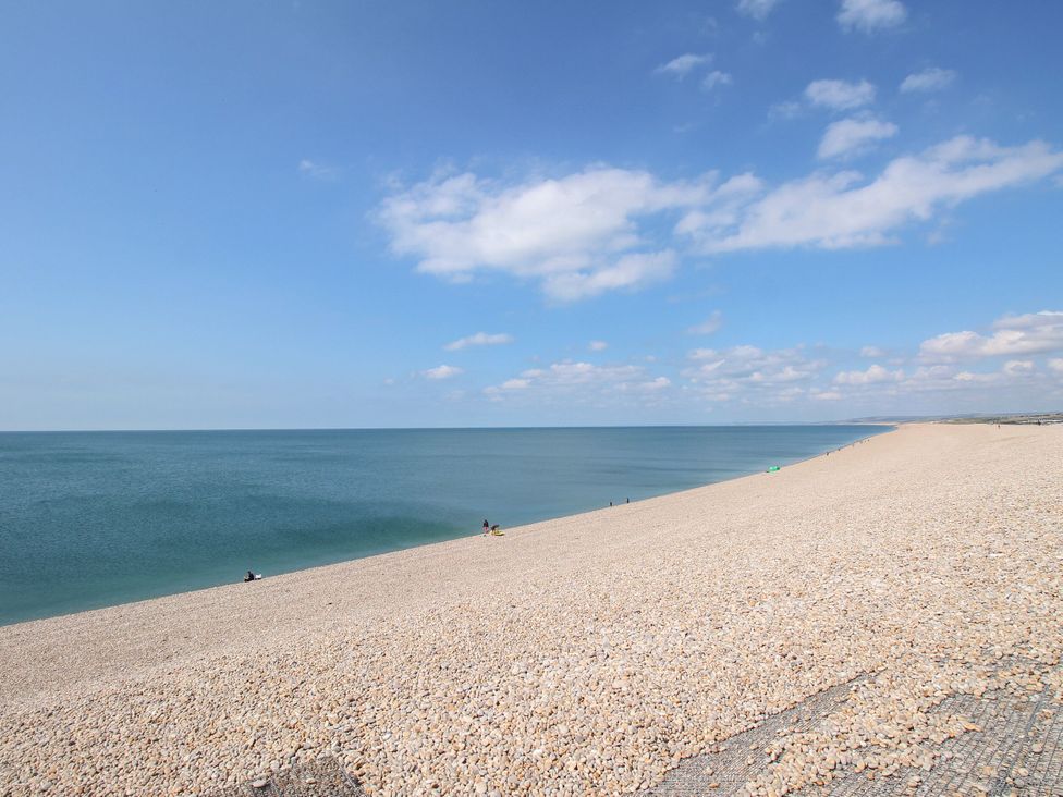 A beach with pebbles and sea under a clear sky at Lily's Pad in Weston, Portland