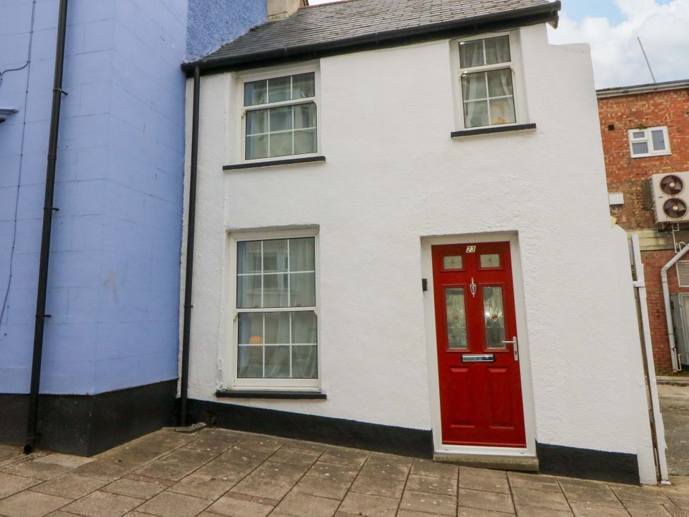 A building exterior with a red door and windows at No.23 Queen St Aberystwyth