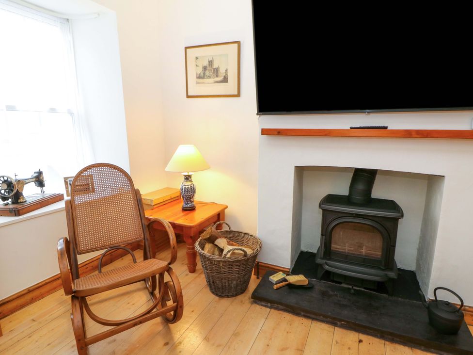 A living room with a rocking chair and a fireplace at No.23 Queen St in Aberystwyth