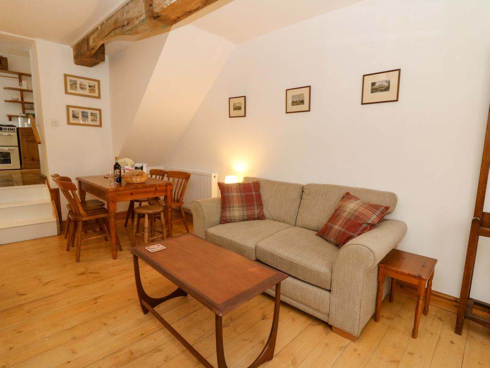 A living room with a sofa and dining area at No.23 Queen St in Aberystwyth