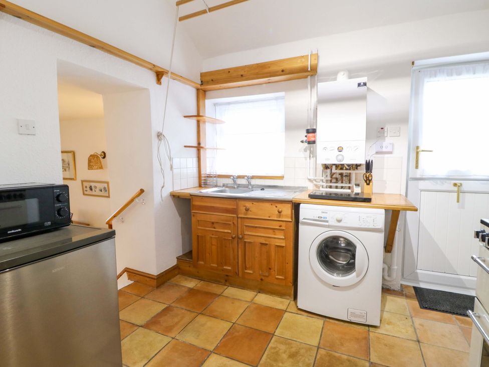 A kitchen with a sink and washing machine at No.23 Queen St Aberystwyth