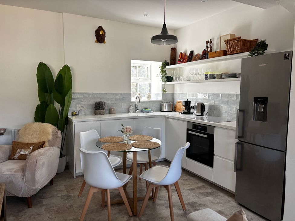 A kitchen with a dining table and chairs at Bracken Cottage in Osmington