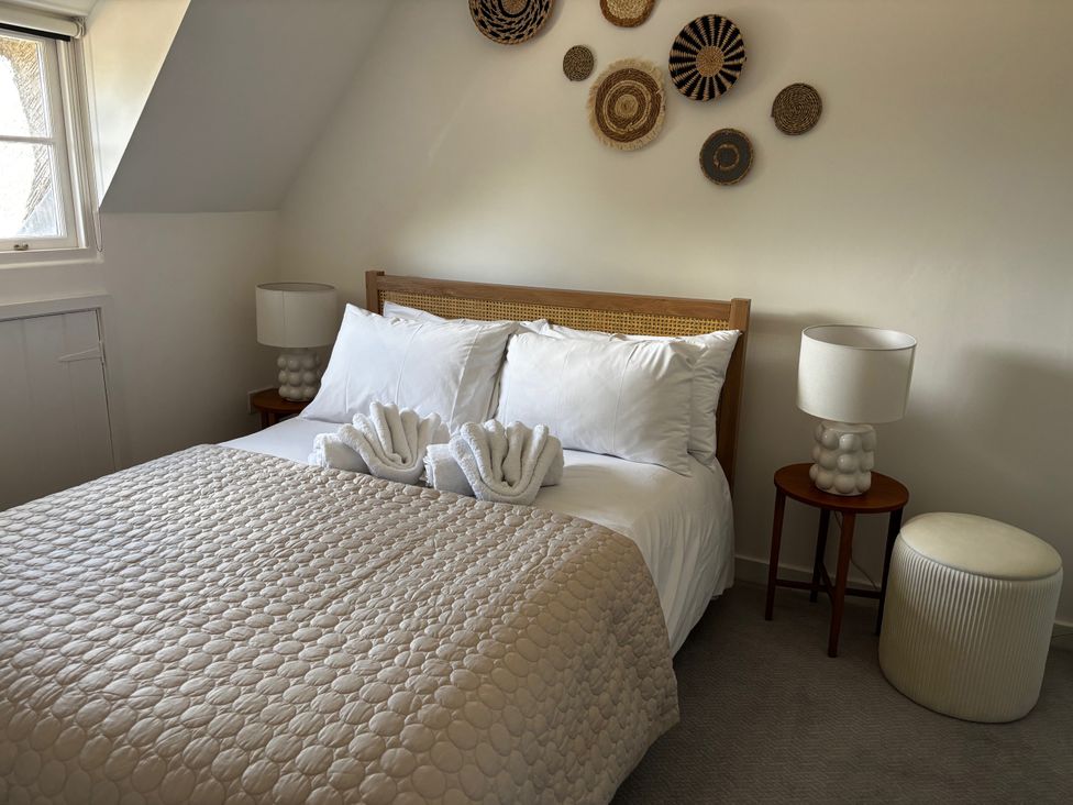 A bedroom with a bed and bedside tables at Bracken Cottage in Osmington