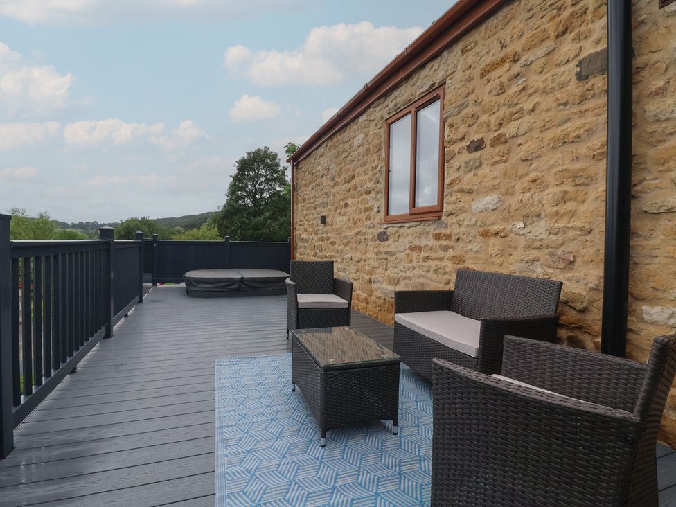 A balcony with outdoor seating and a hot tub at Birch Cottage Scarborough