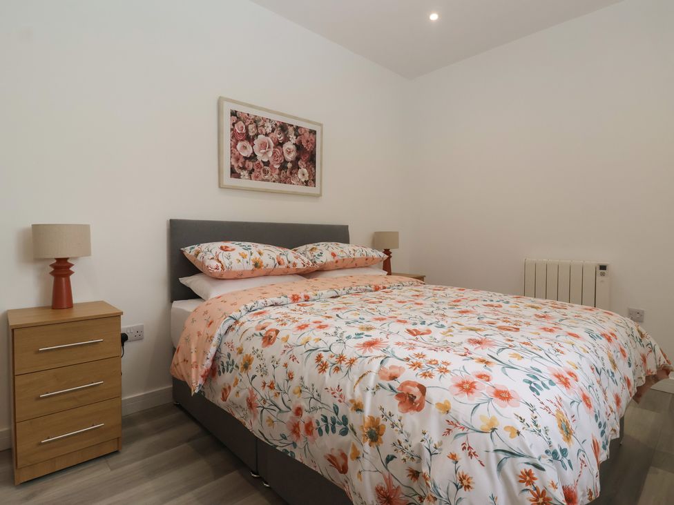 A bedroom with a bed and bedside table at Birch Cottage Scarborough