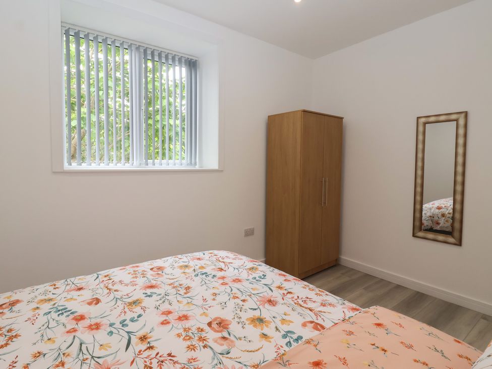 A bedroom with a bed and wardrobe at Birch Cottage in Scarborough