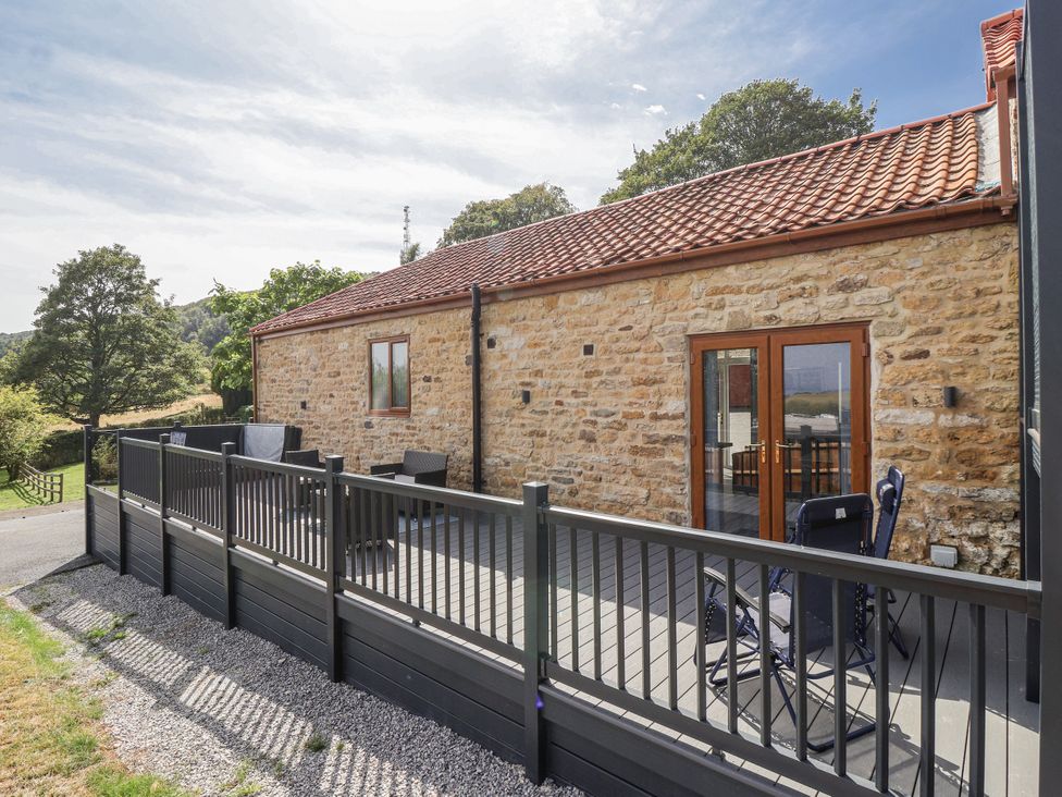 A property with decking and chairs at Birch Cottage in Scarborough