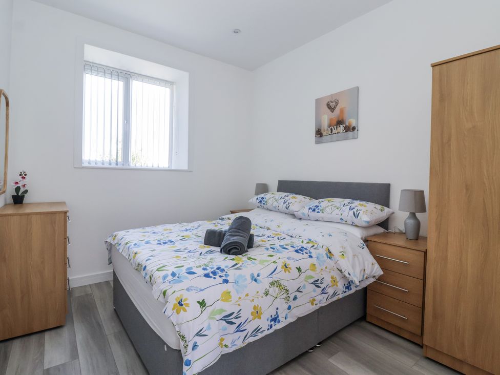 A bedroom with a bed and bedside tables at Birch Cottage in Scarborough