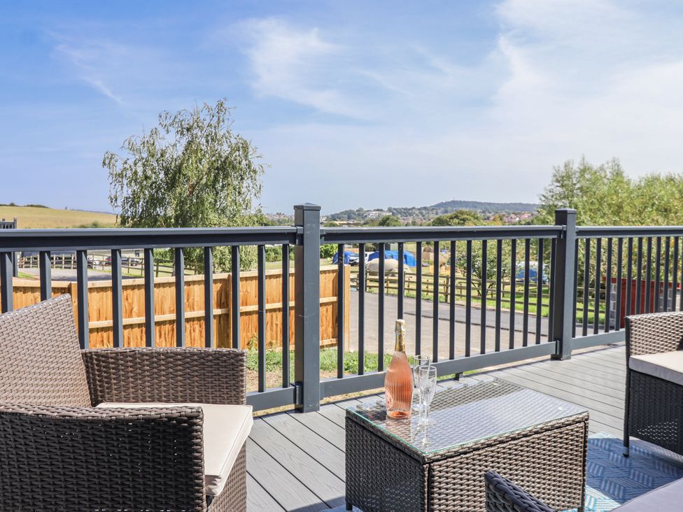 A deck with chairs and a table at Birch Cottage in Scarborough