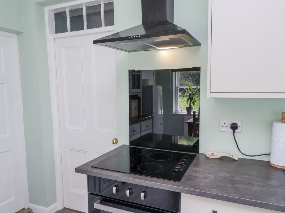 A kitchen with a cooker and extractor hood at Whinstone Cottage Esk Valley near Grosmont