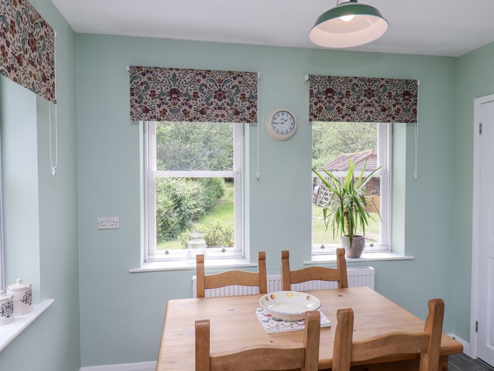 A dining room with a table and chairs at Whinstone Cottage Esk Valley near Grosmont