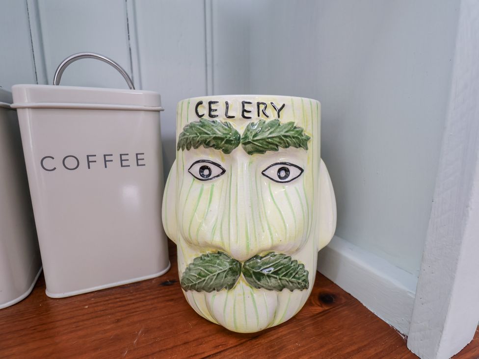 A celery-shaped mug next to a coffee tin at Whinstone Cottage Esk Valley near Grosmont