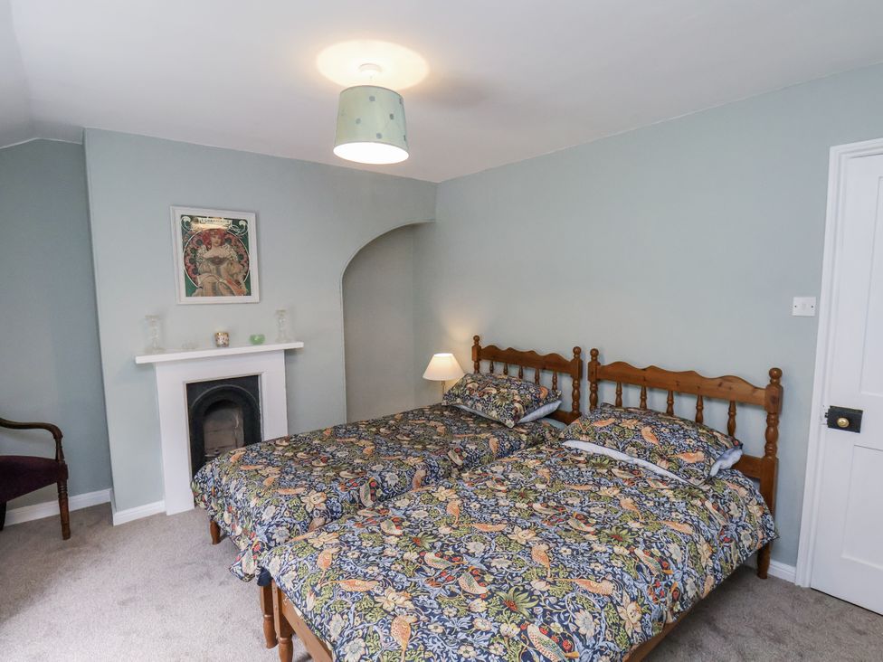 A bedroom with two beds and a fireplace at Whinstone Cottage Esk Valley near Grosmont