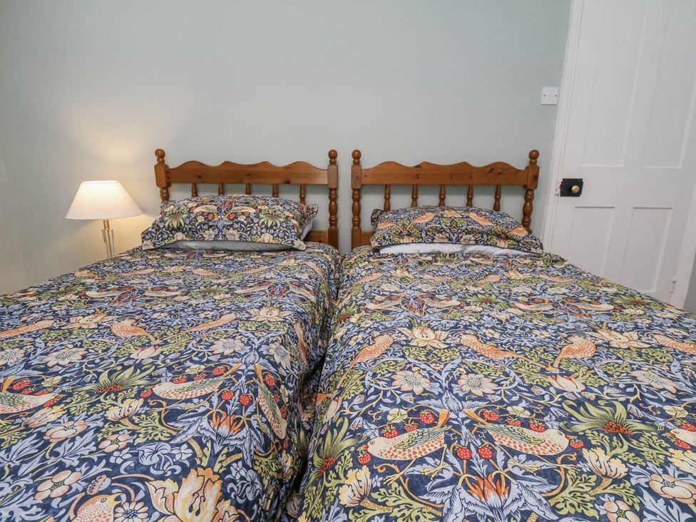 A bedroom with two beds and a lamp at Whinstone Cottage Esk Valley near Grosmont