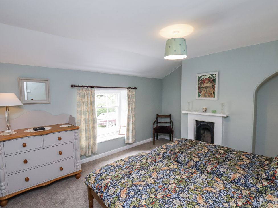 A bedroom with a bed and dresser at Whinstone Cottage in Esk Valley near Grosmont