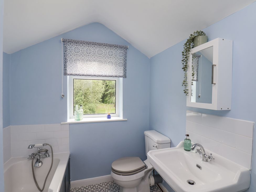 A bathroom with a bathtub, toilet, and sink at Whinstone Cottage Esk Valley near Grosmont