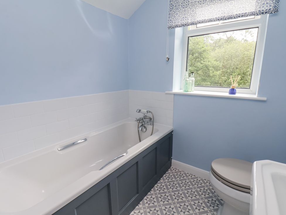 A bathroom with a bathtub and a toilet at Whinstone Cottage in Esk Valley near Grosmont