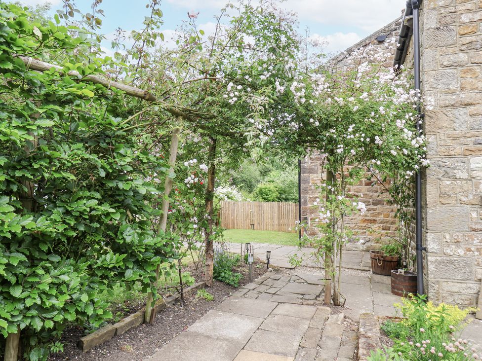 A garden pathway with flowers and greenery at Whinstone Cottage Esk Valley near Grosmont