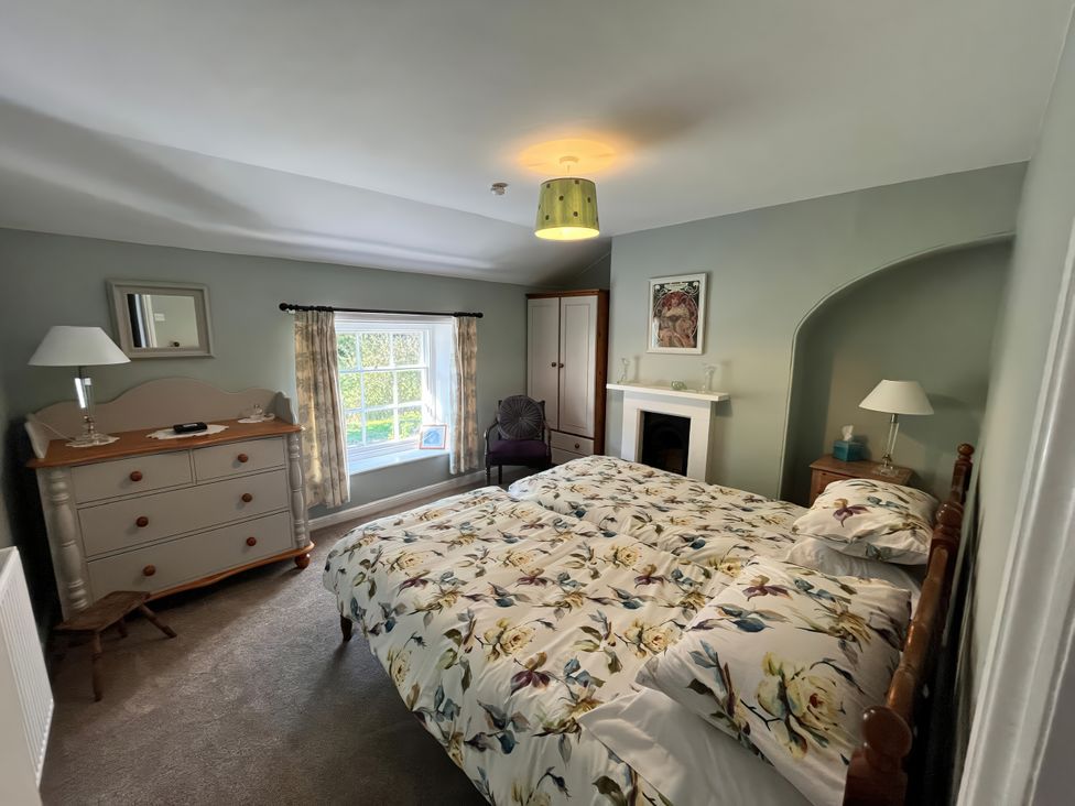 A bedroom with a bed and dresser at 2 Whinstone Cottage Esk Valley near Grosmont
