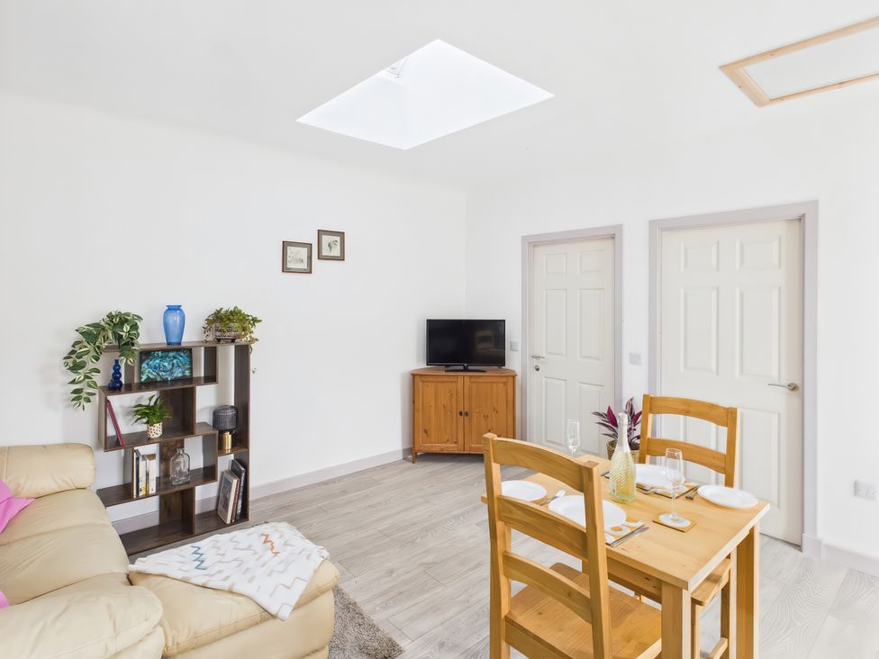 A living room with a dining table and couch at Bathach Beag in Balvicar, Isle Of Seil