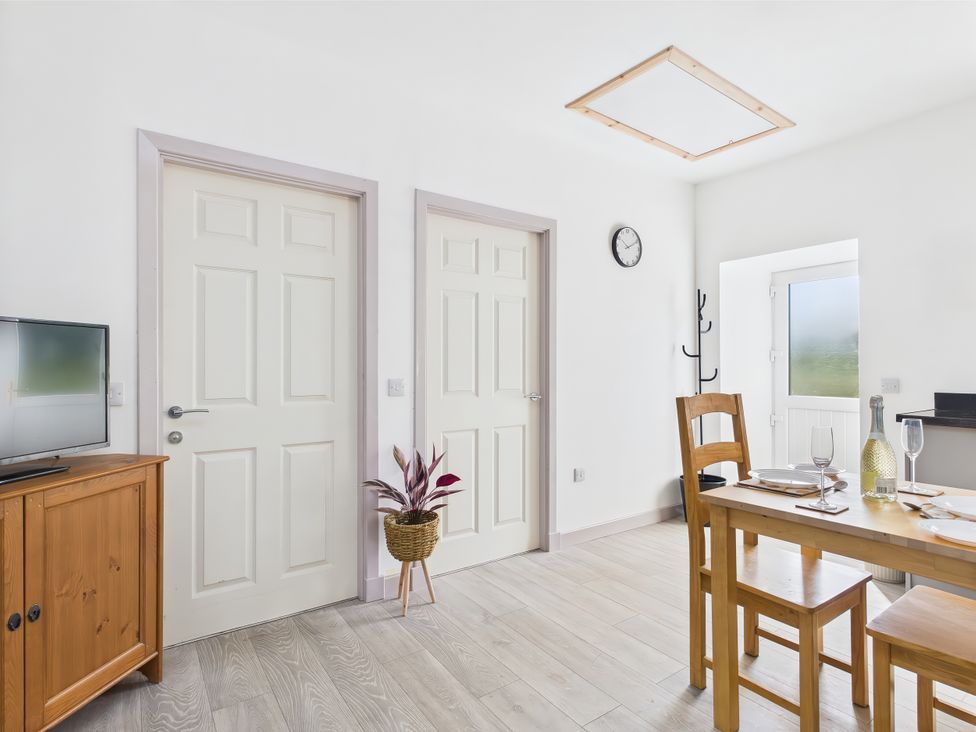 A dining room with a table and chairs at Bathach Beag in Balvicar, Isle Of Seil