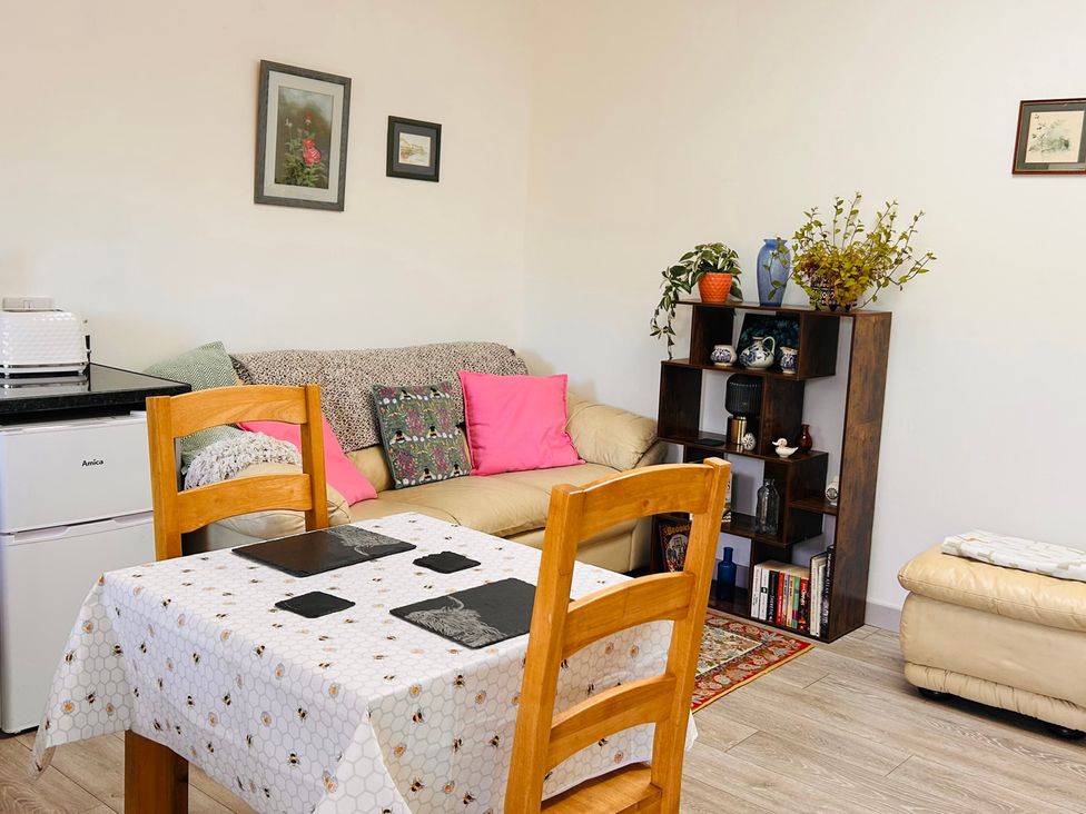 A living room with a table and chairs at Bathach Beag in Balvicar, Isle Of Seil