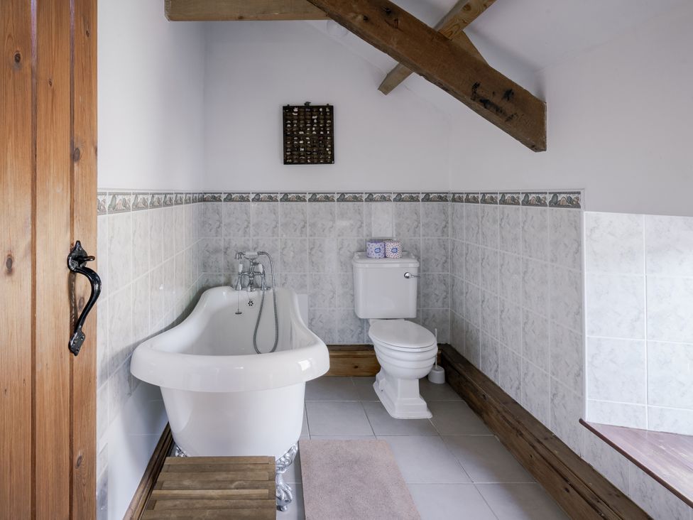 A bathroom with a bathtub and toilet at Cove Cottage Llangrannog
