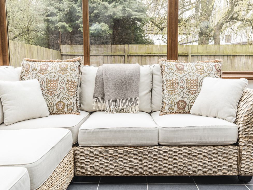 A couch with pillows and a blanket at Y Bwthyn in Llangrannog