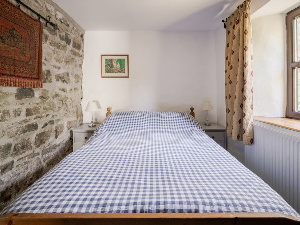 A bedroom with a bed and lamp at Coach House in Llangrannog