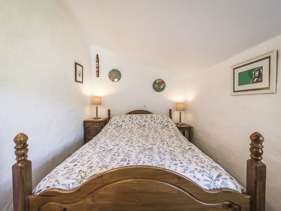 A bedroom with a bed and lamps at Coach House in Llangrannog